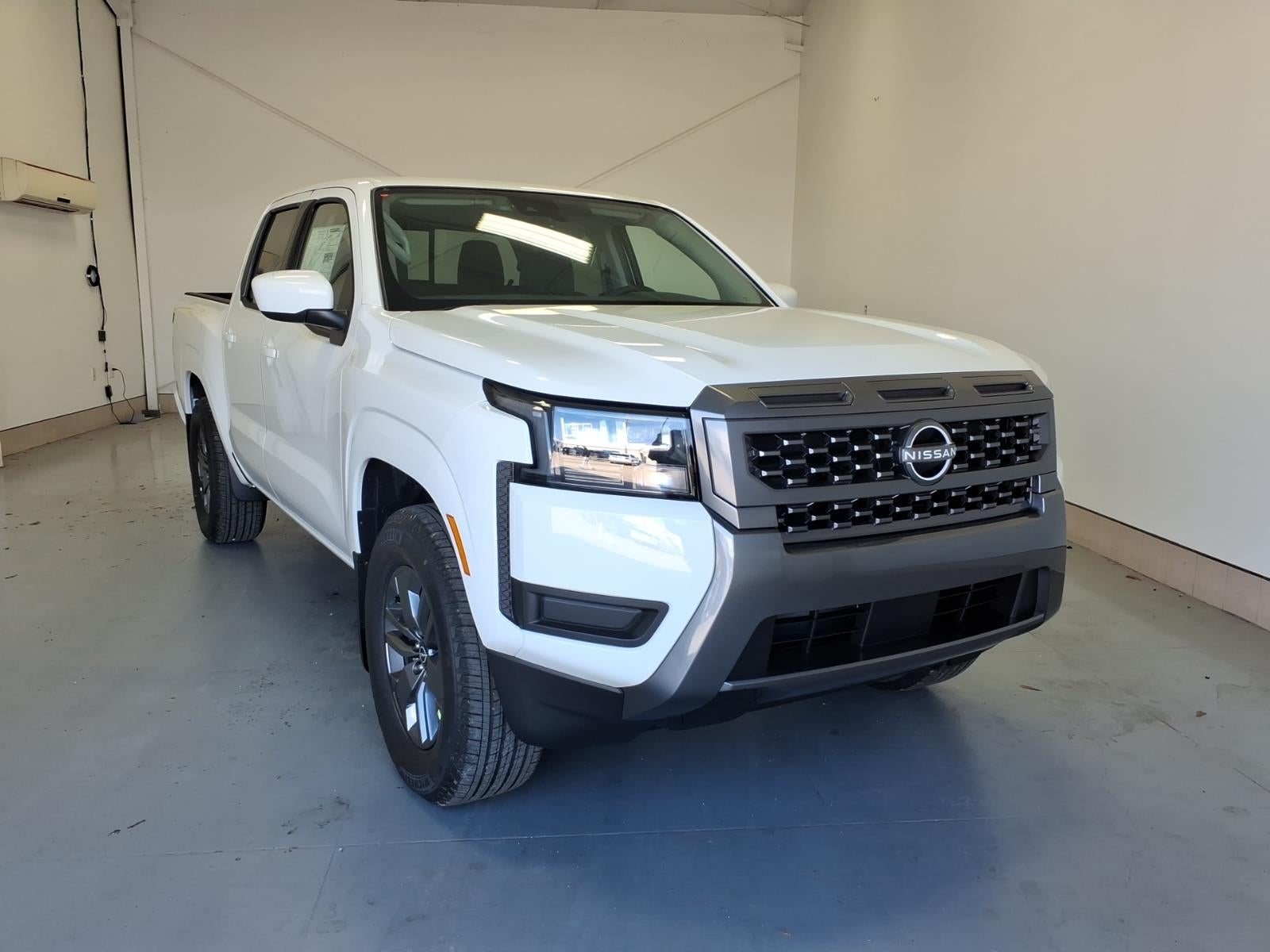 2026 Nissan Frontier SV in Glacier White Qak — front three-quarter view