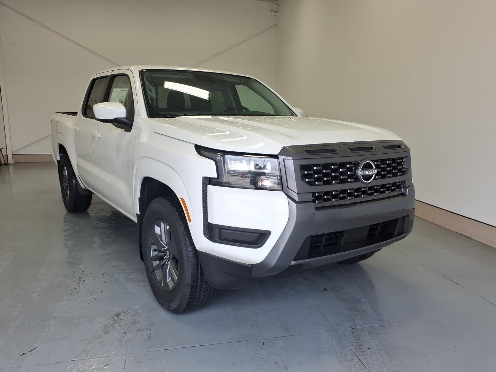 2026 Nissan Frontier SV in Glacier White Qak — front three-quarter view